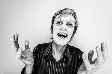 Studio portrait of a screaming guy with a face covered in flour