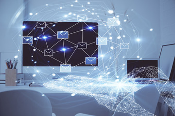 Desktop computer background in office and flying envelops hologram drawing. Double exposure. Electronic mail concept.