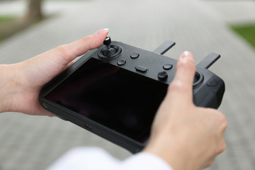Woman with modern drone controller outdoors, closeup