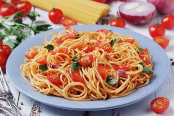 A plate with spaghetti with tomatoes