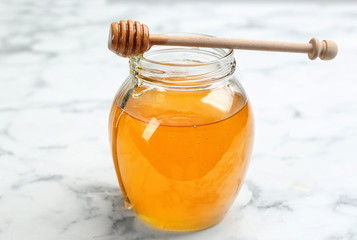 Tasty honey on white marble table, closeup
