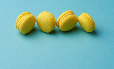 yellow lemon round baked macarons cakes on a blue background
