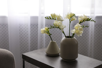 Beautiful spring freesia flowers on table in room