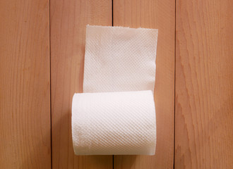 Simple toilet paper on wood background.