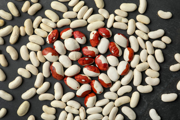 Raw beans on black background, flat lay. Vegetable seeds