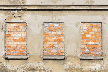 Three bricked up windows background. Grunge abandoned building. Concrete wall with bricks texture.