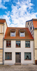 Small old house with blue sky and clouds in the old town of Wismar.