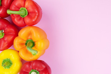 above view of bell peppers on pink colored background