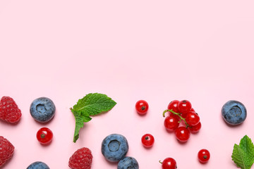 Mix of fresh berries on pink background, flat lay. Space for text