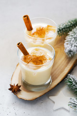 Eggnog cocktail, creamy christmas drink with spice cinnnamon on white background