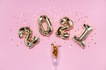 2021 golden foil balloons numbers, champagne, stars confetti, ribbons  and bokeh. Top horizontal...