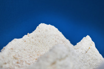 Mehllandschaft mit Vollkornmehl vor blauem Himmel, Berge aus Mehl, Vollmehl mit Schrot fürs Backen zu weihnachten