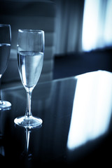 Two glasses of water on a glass table