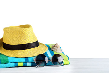 Composition with different beach objects on light grey wooden table, white background