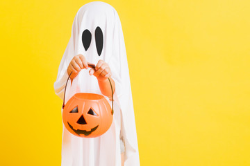 Funny Halloween Kid Concept, little cute child with white dressed costume halloween ghost scary he...