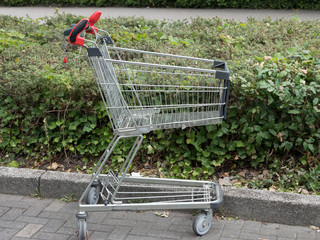 abgestellter leerer Einkaufswagen auf einem Parkplatz