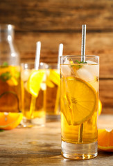Delicious refreshing drink with orange slices on wooden table
