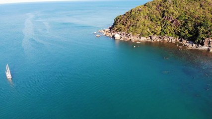 Boat near tropical shore. Amazing drone view of modern yacht sailing on calm sea water near coast of tropical volcanic island. Exotic Paradise Koh Samui, Silver Beach.
