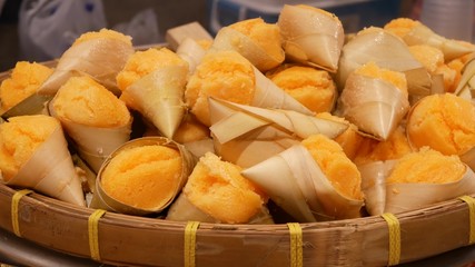 Exotic Oriental Asian sweet delicious desserts, unusual colorful traditional dishes on the counters of a bazar with street food. Evening food court in bangkok, the capital of cooking. Night market