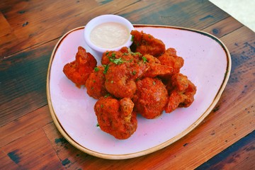 Platter of vegan buffalo cauliflower with ranch dressing
