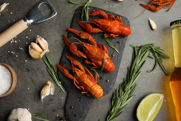 Flat lay composition with delicious red boiled crayfishes on black table