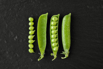 Fresh green juicy peas on black background