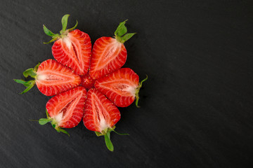 Fresh Juicy Ripe Cut Strawberries on black background. Macro photo.