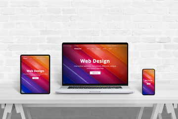 Responsive web site presentation concept on tablet, laptop and smart phone on white studio desk