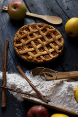Homemade lattice Apple pie with cinnamon on an old textured wooden background