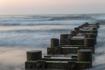 Ocean waves crashing into pylons 