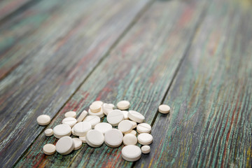 Fototapeta na wymiar White pill on a wooden background