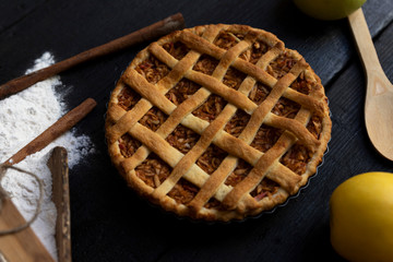 Homemade lattice Apple pie with cinnamon on an old textured wooden background. Top view