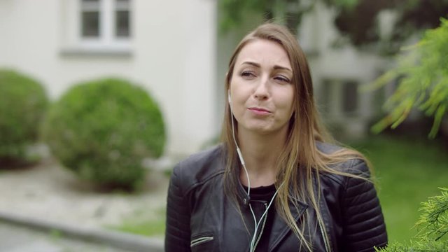 Young Woman Is Talking On The Phone With Her Headphones.