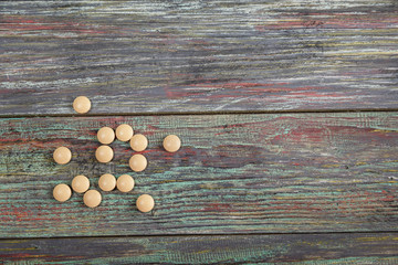 Beige pill on a wooden background with copy space.