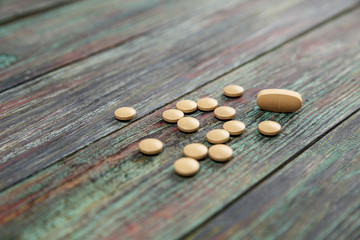 Beige pill on a wooden background with copy space.