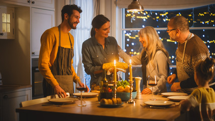 Multi Generation Family of Celebrating together, Gathering around the Table with Delicious Dinner Meal. Young Mother Takes Dish out of Oven Grandparents Admire How Delicious Casserole Looks