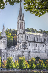 Fototapeta na wymiar Virgin of Lourdes. Place of power. Pilgrimage for the purpose of healing. Grotto Masabiel. Saint Bernadette Soubirous. Holy Rosary. Sanctuary at Lourdes. The city of pilgrims in Europe.