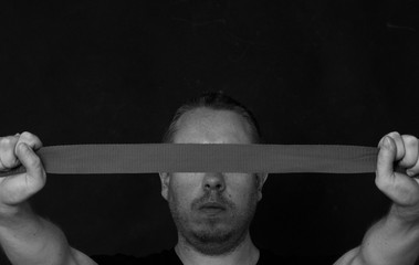 man holding a ribbon in front of his head
