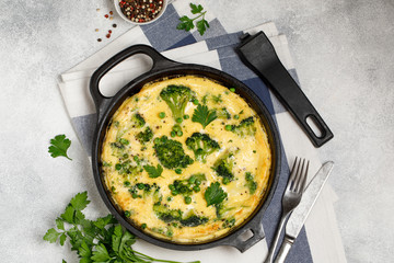 Omelette with green vegetables, broccoli and green pea in a frying pan.