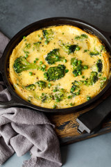 Omelette with green vegetables, broccoli and green pea in a frying pan.