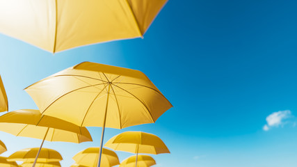 Fototapeta na wymiar Yellow beach umbrellas against the blue sky