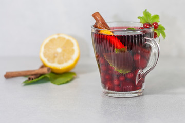 Red drink with fruits, lemon and cinnamon on a light background
