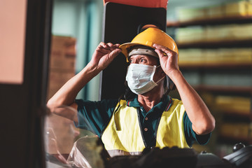 Asian warehouse worker wear face mask as new normal after Covid 19