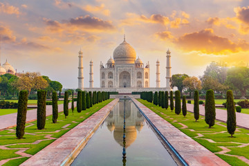 Taj Mahal front view reflected on the reflection pool, an ivory-white marble mausoleum on the south...