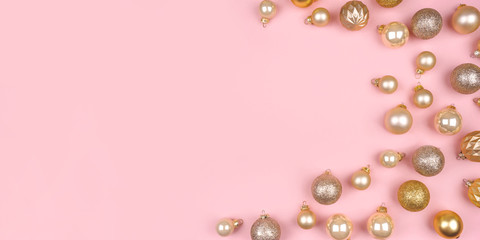 Festive pink background with gold and silver christmas balls. Flat lay, top view. Copy space for your text.