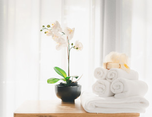 Obraz na płótnie Canvas Spa products with white towels,soap,luffa scrub,comb and beautiful orchid flower in clean white room