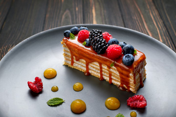 One piece of pie, honey cake with fresh berries, mint, and caramel