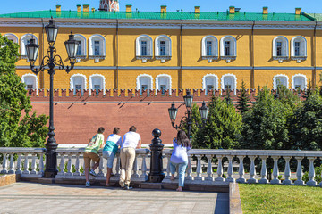 Obraz premium Tourists leaned on the railing and look at the Alexander garden and the Kremlin wall