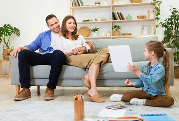 Daughter Showing Sketch To Parents Spending Time Together At Home