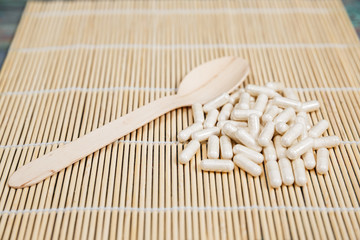 Fototapeta na wymiar Alternative medicine tablets on a wooden spoon
